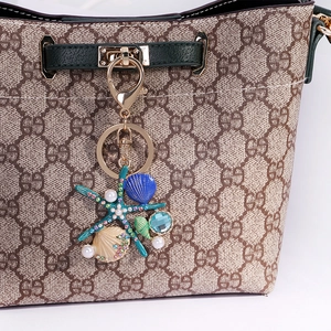 Porte-clés thème marin avec étoile de mer verte, coquillages et perles sur sac