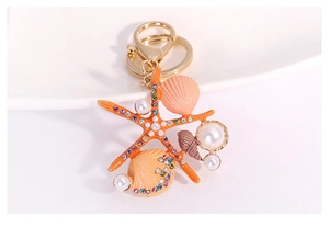 Détail d'un porte-clés étoile de mer avec coquillages et perles sur céramique