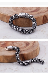Detailed close-up of heavy punk skull links on a vintage stainless steel bracelet