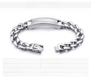 Macro shot of silver stainless steel curb chain bracelet with stone-set rectangle plate