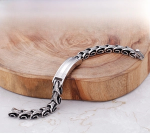 Macro shot of men's vintage dragon scale link bracelet with polished metal plate