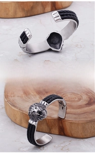 Makroaufnahme des silbernen Edelstahl-Löwenkopf-Armbands mit schwarzen Flechtdetails