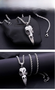 Macro shot of gothic raven skull pendant made of durable stainless steel on twist chain