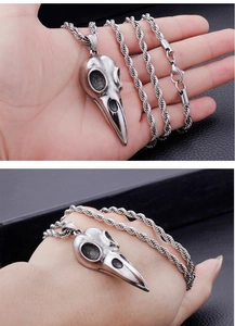 Detail of vintage silver bird skull pendant on stainless steel twisted chain necklace