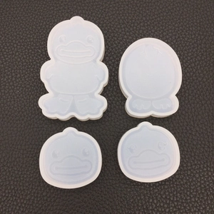 Detailed view of four silicone duck molds for DIY resin casting on a black textured background