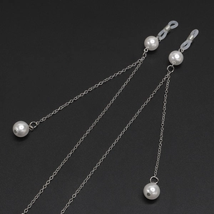 Silver metal glasses chain with white pearls on a black background, high-gloss finish