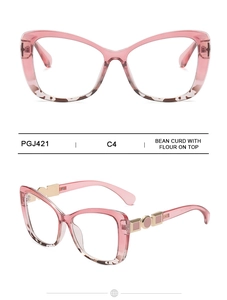 Detail of pink cat-eye glasses frame with gold geometric metal hinges and tortoise accents