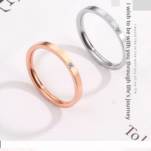 Close-up of minimalist rose gold and silver couple rings with single square diamonds