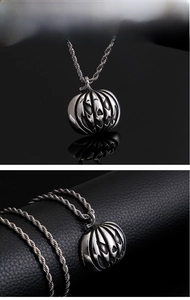 Vue macro du pendentif citrouille d'Halloween en argent antique sur fond de cuir noir