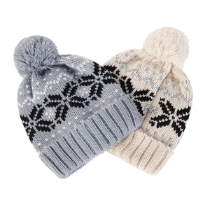 Détail de bonnets en tricot gris et beige avec motifs flocons de neige noirs et pompons