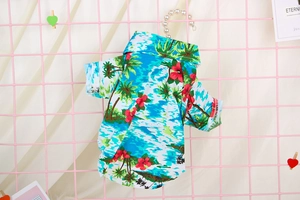 Detail of tropical pet shirt featuring coconut trees and hibiscus floral print