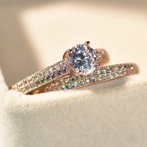 Rose gold wedding ring set with round brilliant cut diamond in a beige jewelry box