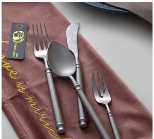 Detail of stone-washed vintage silver stainless steel cutlery set with ringed handles