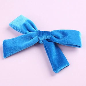 Detail shot of a 5-inch bright blue velvet hair bow with a silver metal alligator clip