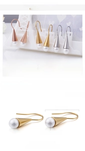 Detail of 18K gold plated stainless steel cone earrings with elegant shell pearl