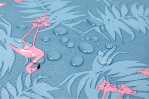 Macro shot of blue flamingo print fabric showing water droplets and waterproof texture