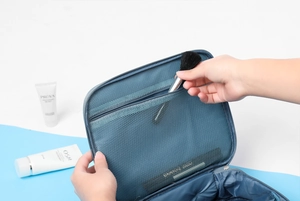 Detail of blue-grey waterproof cosmetic bag showing inner mesh pocket for brushes