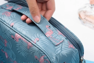Detail of teal flamingo cosmetic bag with top handle and secure zipper closure