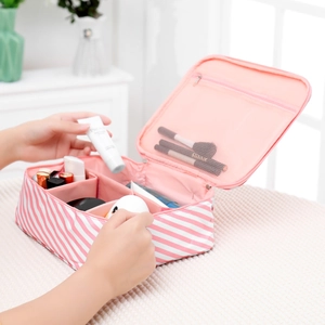 Detail view of striped travel cosmetic bag with multiple mesh compartments and brush slots