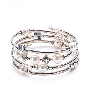 Detail of multi-layer wrap bracelet featuring white shell pearls and silver floral beads