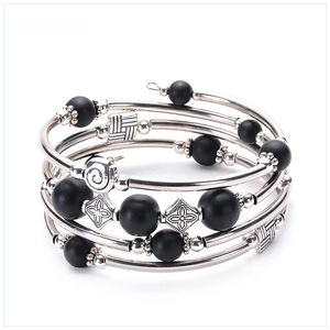 Macro detail of multi-layer wrap bracelet featuring matte stones and silver metal tubes
