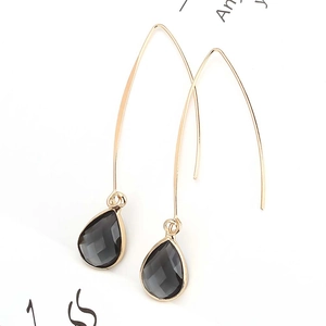 Elegant gold hook earrings with dark gray faceted teardrop crystal pendants on white background
