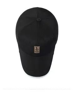 Détail d'une casquette de baseball noire matelassée avec un écusson logo en cuir brun