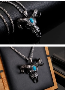 Close-up of a silver devil sheep head skull pendant with turquoise stone inlay on a chain