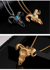 Detail view of silver and gold ram skull pendants with blue gems on black background