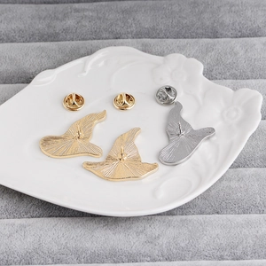 Macro view of metal wizard hat brooch backs with butterfly pin clutches on a tray
