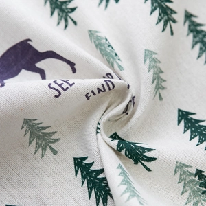 Close-up of linen fabric texture with deer and pine tree prints for door curtains