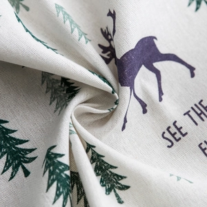 Close-up of cotton linen fabric texture with deer and pine tree printed pattern