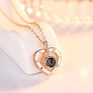 Rose gold heart necklace with 100 languages projection and Roman numerals on soft bokeh bg