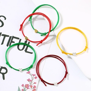 Close-up of adjustable heart charm bracelets in colorful cord with metal heart pendants