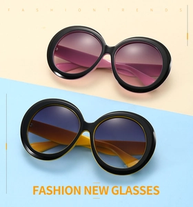 Détail de lunettes de soleil rondes oversize avec verres dégradés roses et bleus