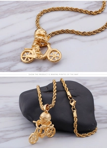 Détail du pendentif biker crâne punk doré avec chaîne de corde texturée sur marbre