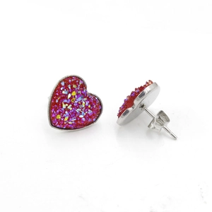 Macro detail of heart-shaped stainless steel earrings with sparkling red druzy stones