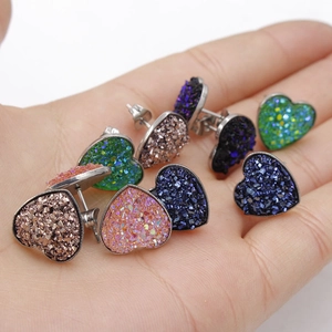 Macro shot of colorful druzy heart studs with sparkling crystal texture and silver posts