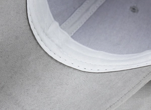 Macro detail of high-quality sewing and white sweatband inside the grey suede baseball cap
