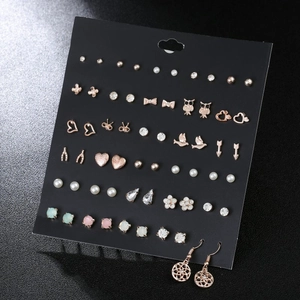 Detailed set of 42 pairs of colorful zircon bow and heart studs on a black card