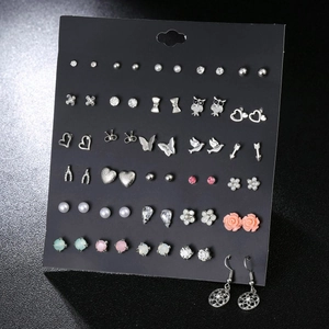 Detailed display of 30 pairs of assorted crystal and pearl stud earrings on a card