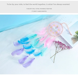 Detail of a handmade pink dreamcatcher with colorful feathers and decorative beads