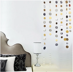 Detail of gold and silver sparkling star and circle garlands hanging on a bedroom wall