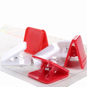 Macro detail of red and white heart-shaped plastic clips scattered on a calendar page