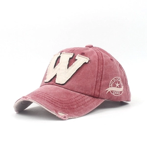 Detailed macro view of vintage washed burgundy cap with distressed brim and W patch