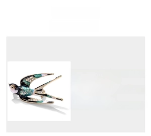 Detailed view of enamel swallow brooch with sparkling rhinestones and metal texture