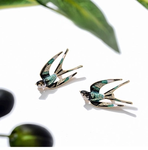 Detail of emerald enamel swallow brooches with micro-inlaid rhinestones on gold alloy