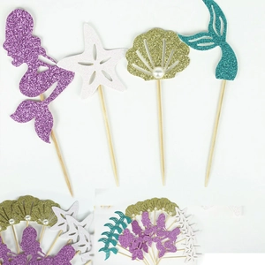 Detailed close-up of glittery mermaid tail and seashell cupcake toppers for parties