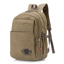 Detail view of khaki canvas backpack with multiple zippers and MIGRATOR logo
