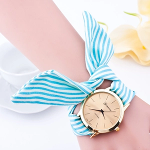 Women's Geneva watch with blue white striped fabric ribbon strap and gold dial on wrist